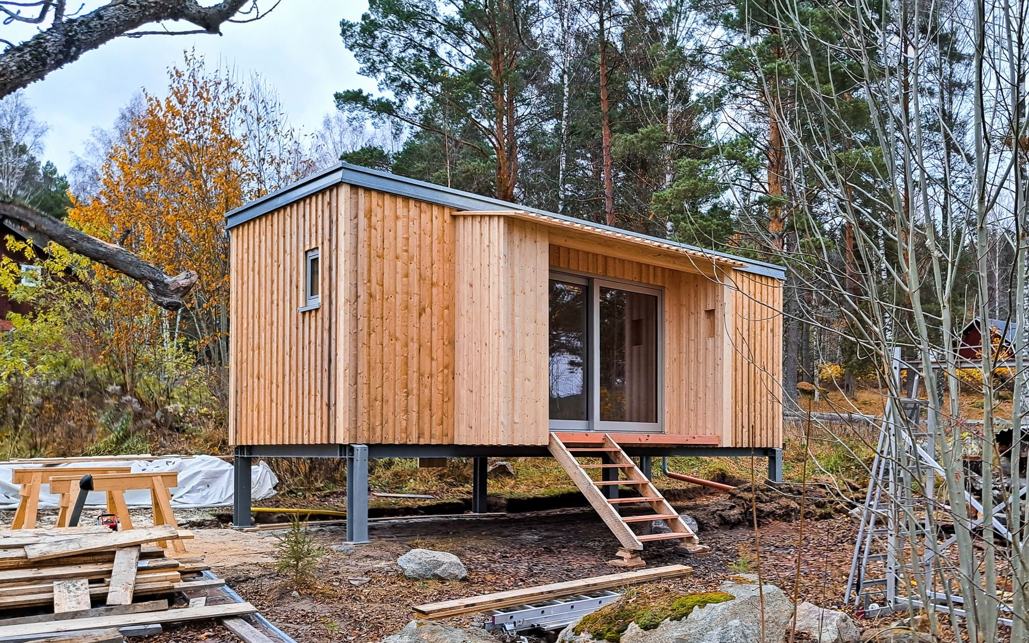 Tinyhouse mit klarer Holzstruktur vor schwedischer Waldkulisse in Gunnarskog