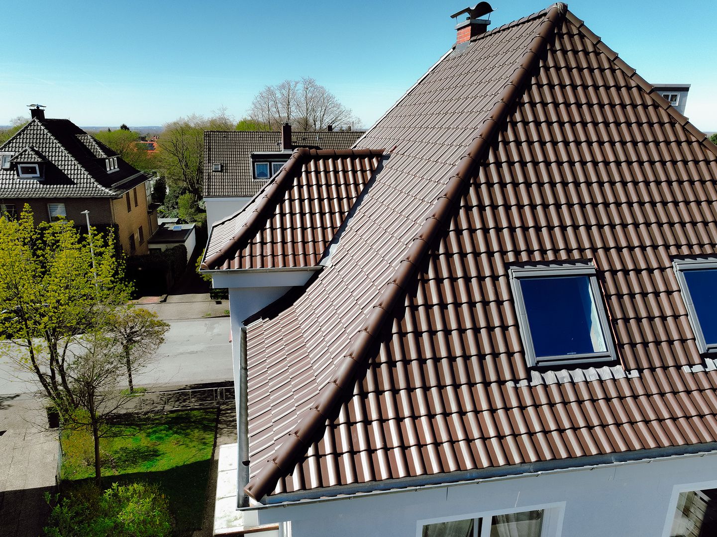 Professionell saniertes Hausdach mit modernen Dachziegeln und Dachfenstern